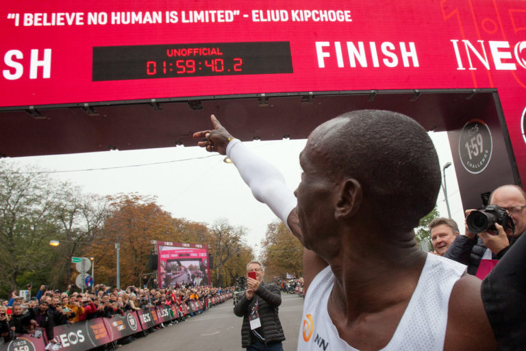 Eliud Kipchohe pointing to finish line clock